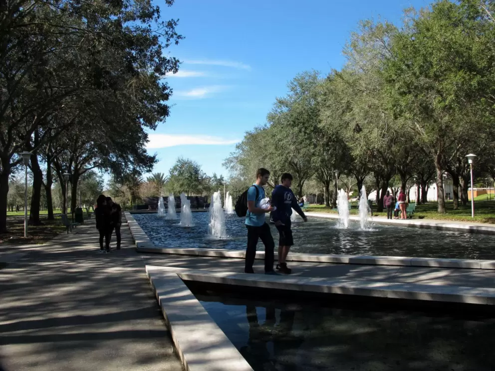 Student walk past the fountains.