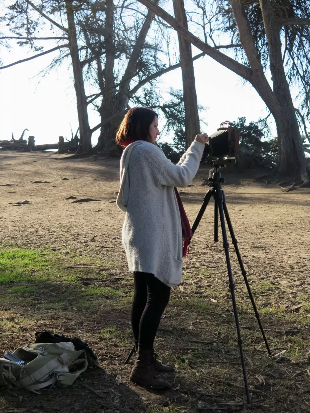 A young woman sets up an old-fashioned camera.