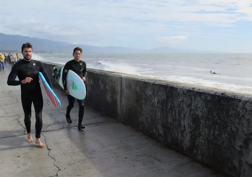 Surfers at the breakwater.