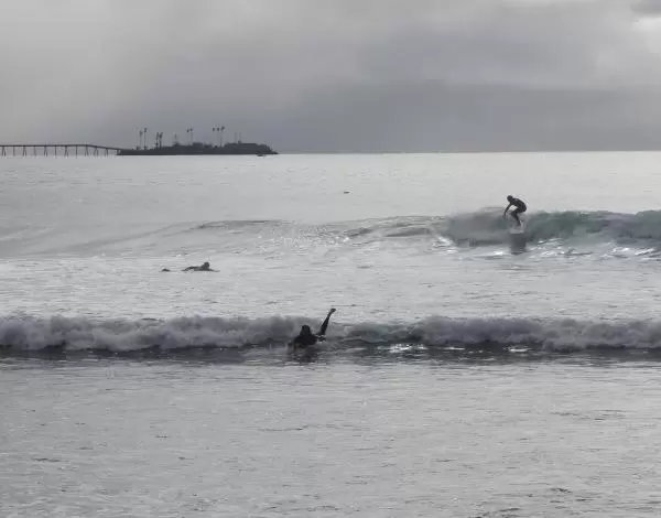 Surfer catching a wave, with the island in the background.