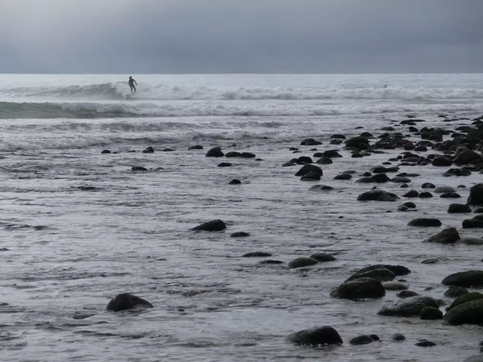 Rocky shore and surfer.