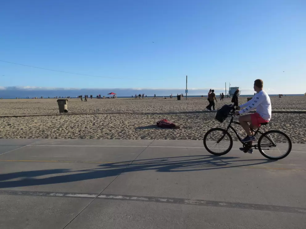 A young man rides along looking toward the sea.