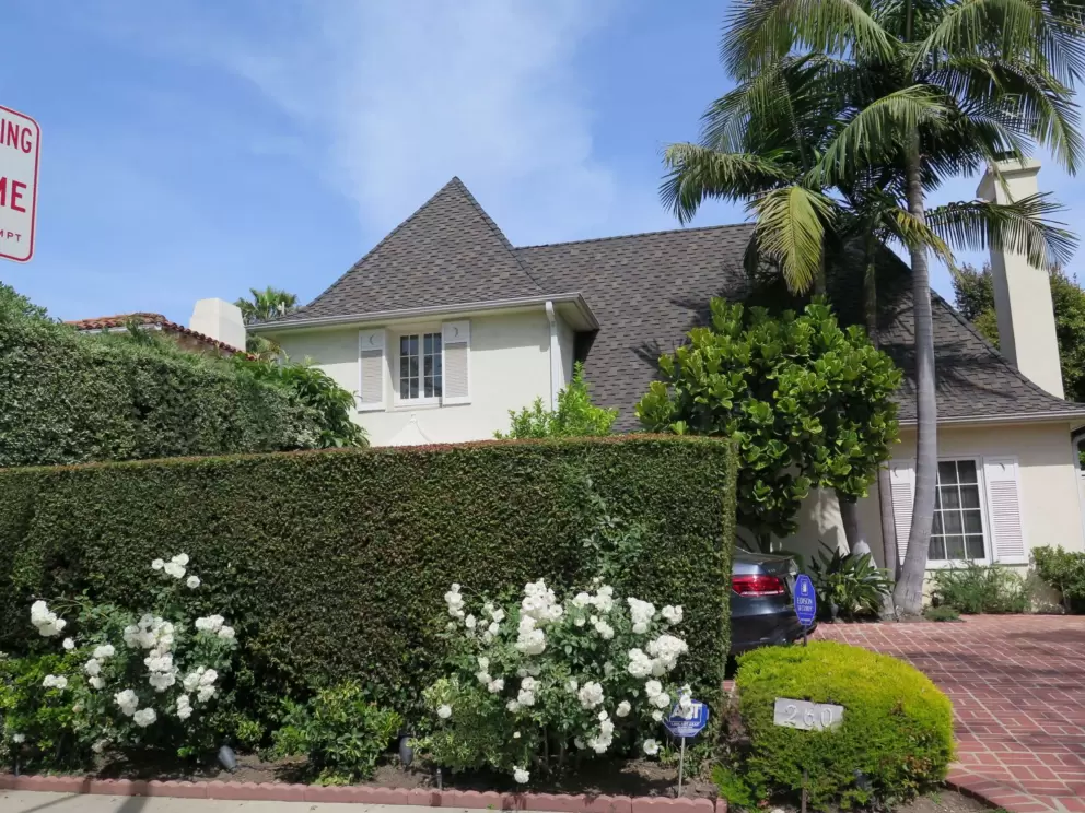 Mansion with pointed roof and roses.