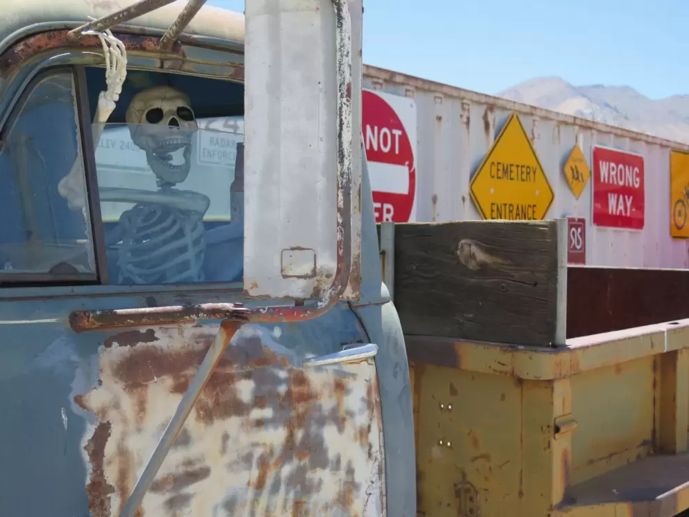 Skeleton driving a truck outside.