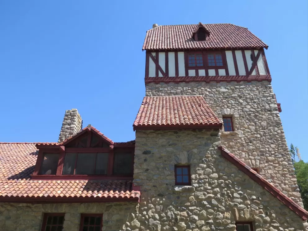 The adorable architecture with stone of all sizes, tiled roof, and half-timbered tower.