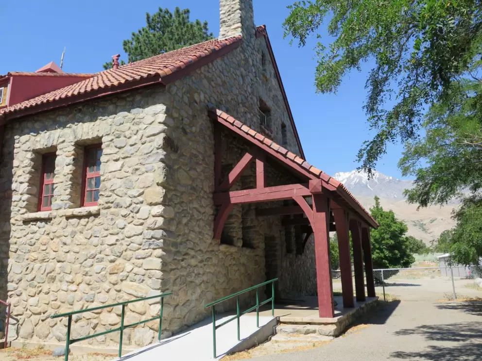 The farthest end of the building, with the snowy mountains behind.