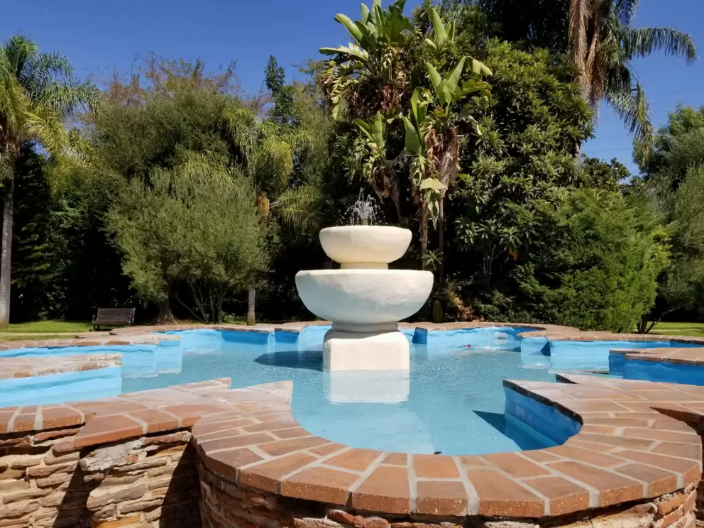 Lovely pale blue fountain and cluster of banana trees!