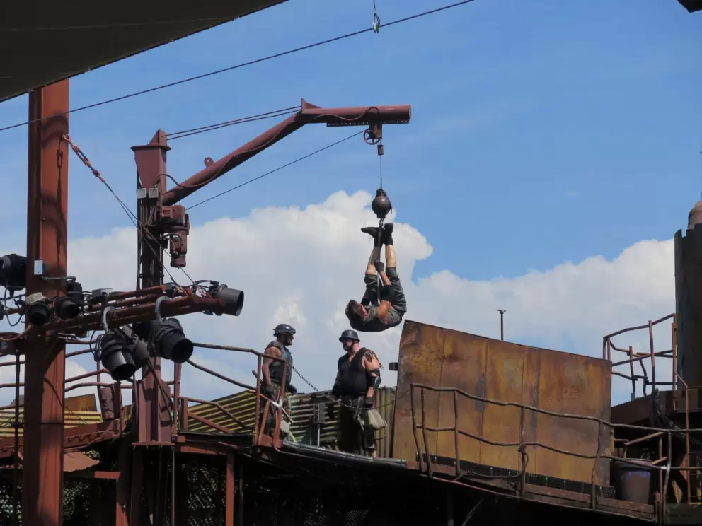 Man hanging by his feet in the Waterworld show.