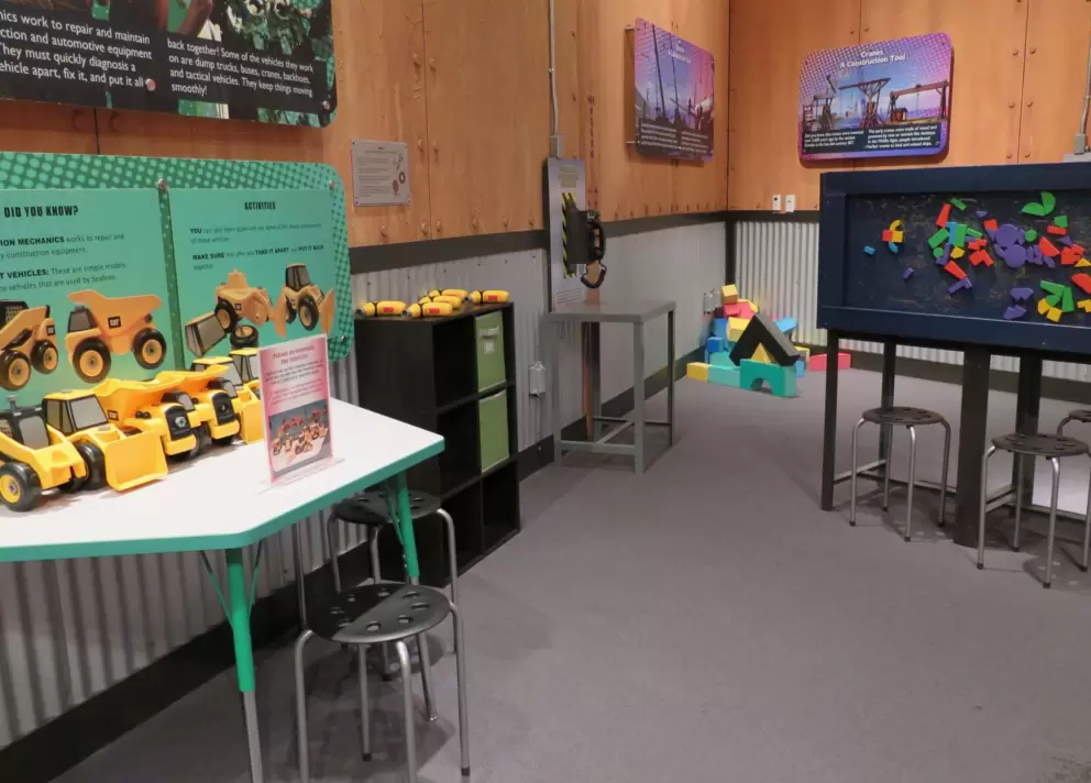 Children's area with gears, electronic projects, magnets, and trucks.