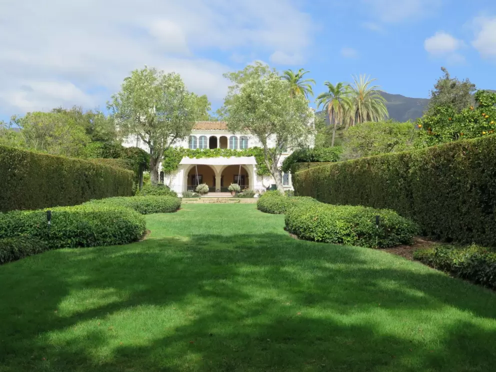 The lawn behind the house and mountains beyond.