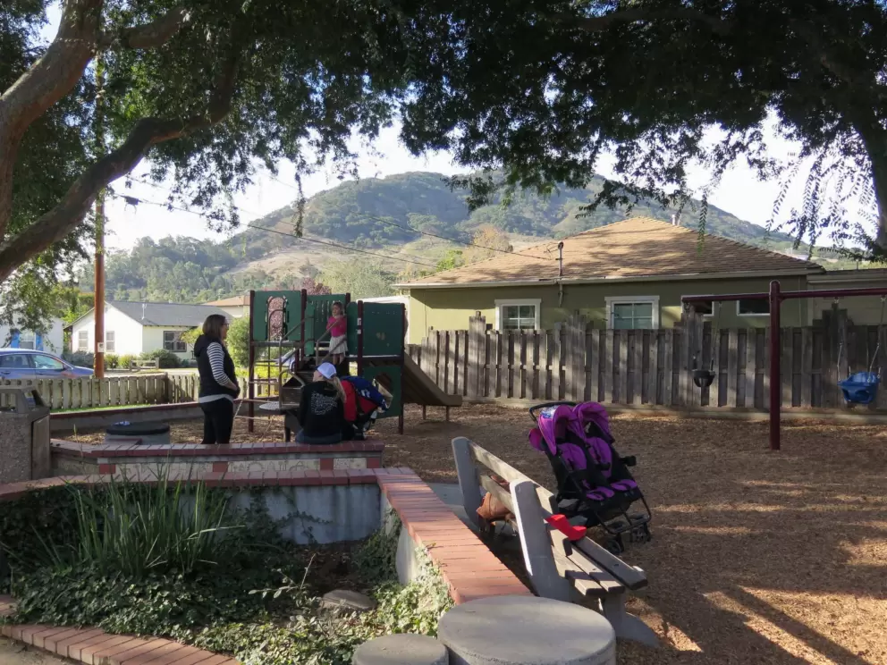Moms gather in the morning at the toddler play structure.