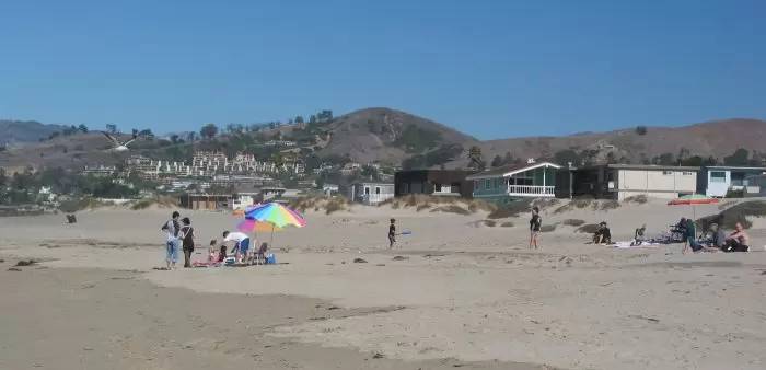 A game of ball, and families hanging out on the beach.