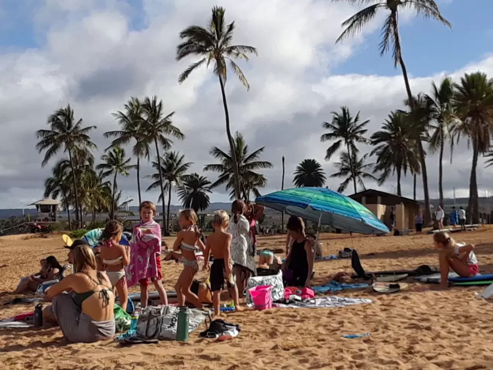 A group of surfing families gather on a weekend morning.