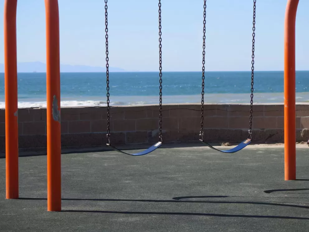 Swings with ocean behind.
