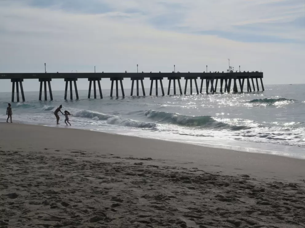 Playing on the shore by the pier in the morning light.