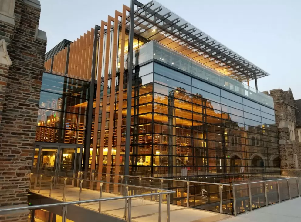 Modern glass cafeteria between historic buildings, at night. This is where you will find the international food court!