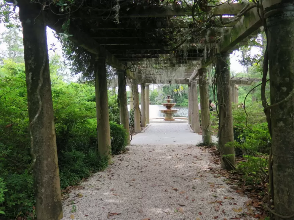 Pergola leading to a tiered fountain.
