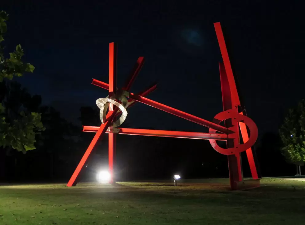 Statue near the parking lot, lit at night.
