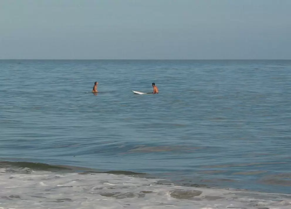 Surfers floating around on a flat summer day.