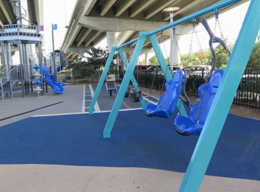 Swings on the playground, and toddler area in the distance.