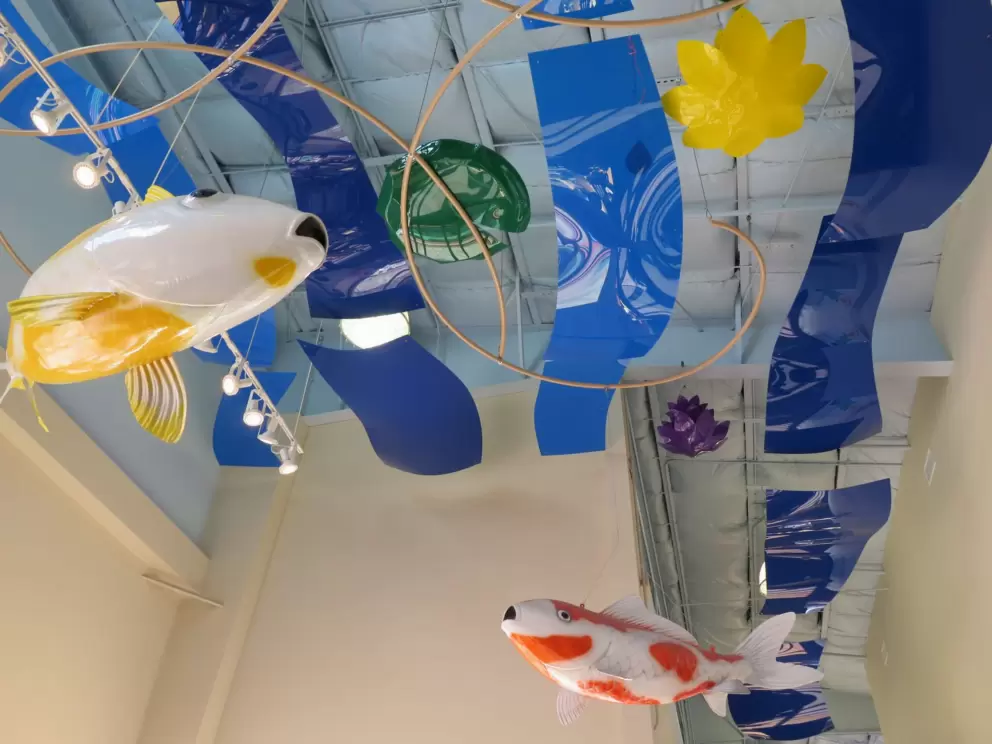 Fish sculptures hanging from the ceiling in the lobby.