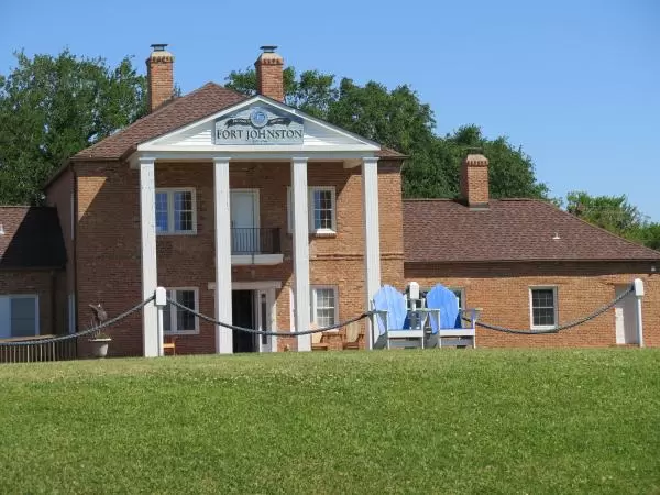 Fort Johnston building and blue adirondack chairs.