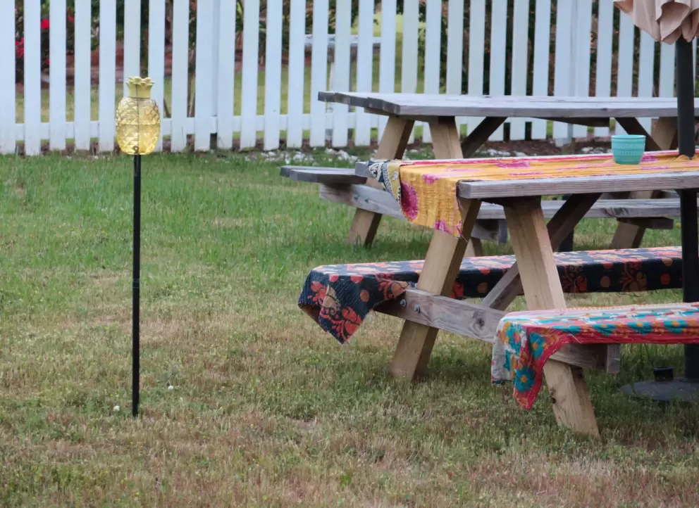 Pineapple decoration and picnic tables behind Short Street vacation rentals.