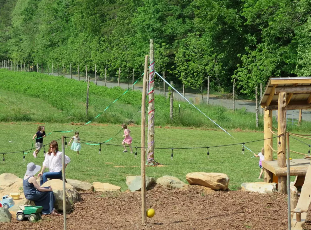 Girls run around the maypole.