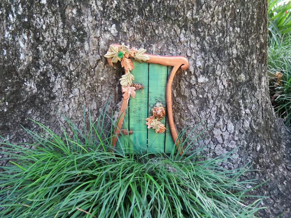 Fairy door with clump of grass.