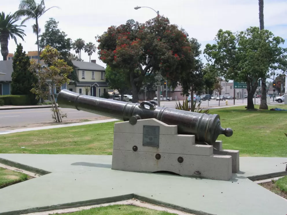 Old Spanish cannon and historical houses behind. 
