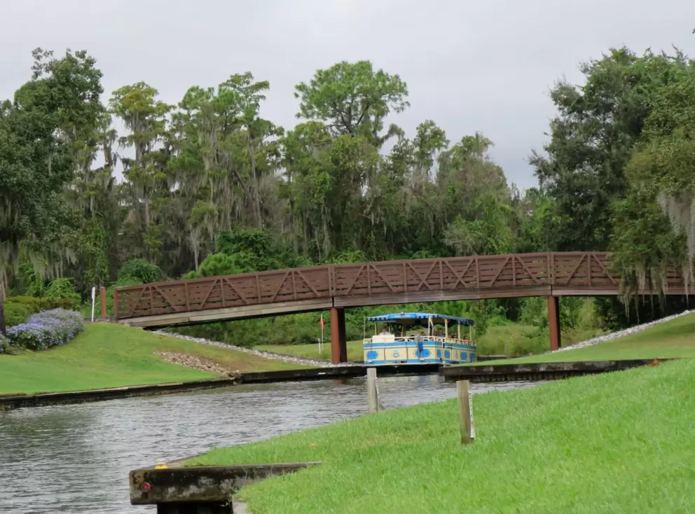 A ferry goes under a bridge.