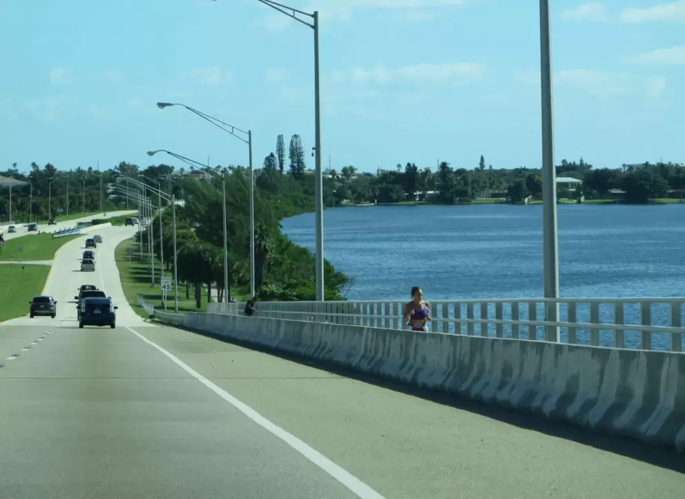 A woman jogs over the causeway, nearby. 