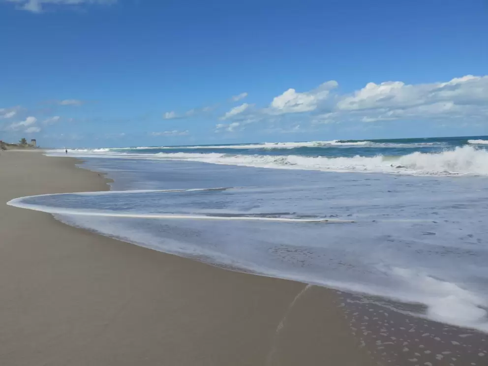 The shore is pounded with surf.