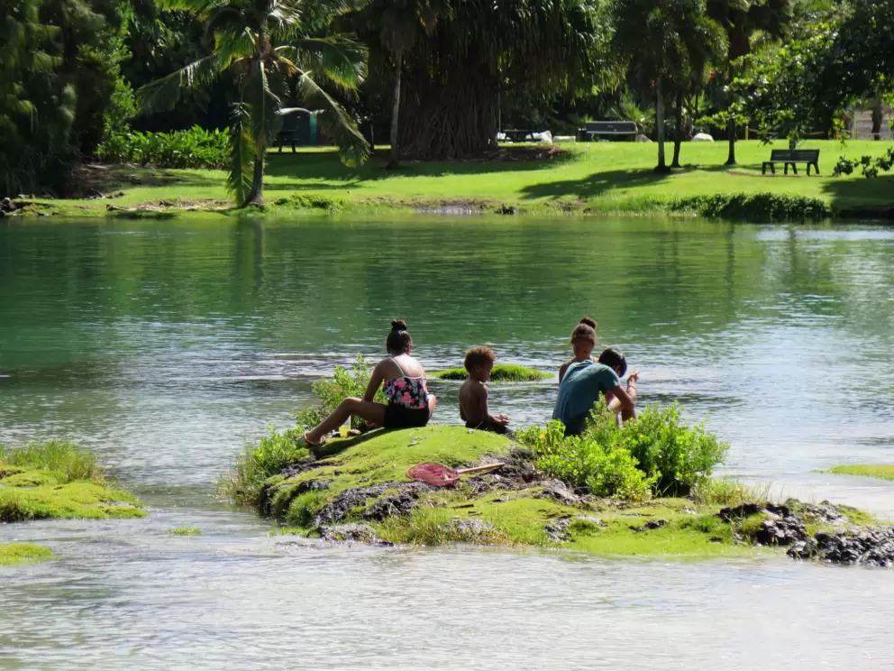 Kids gathered on an island in the bay, playing.