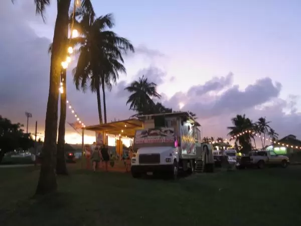 Strung lights, palm trees, and food trucks.