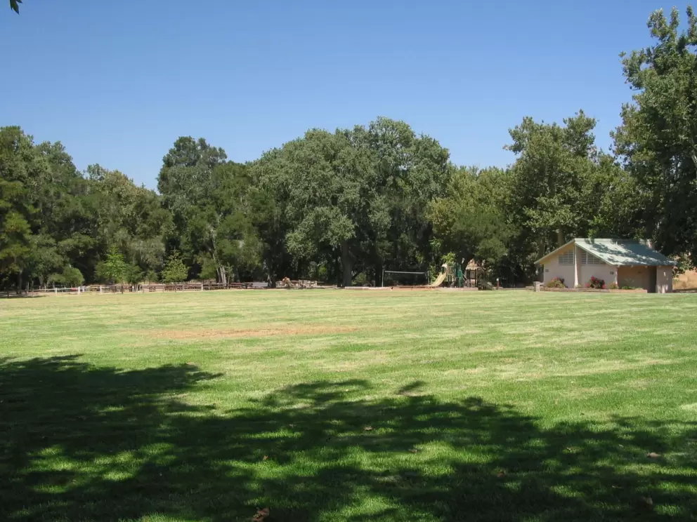 Large field and playground at Nojoqui Park. There are several play structures scattered about the area.