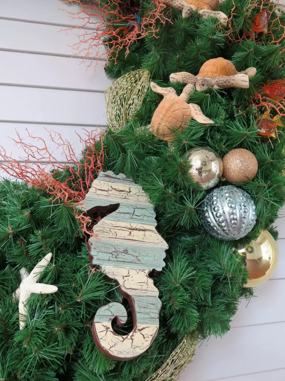 Seahorse, turtles, and starfish in wreath.