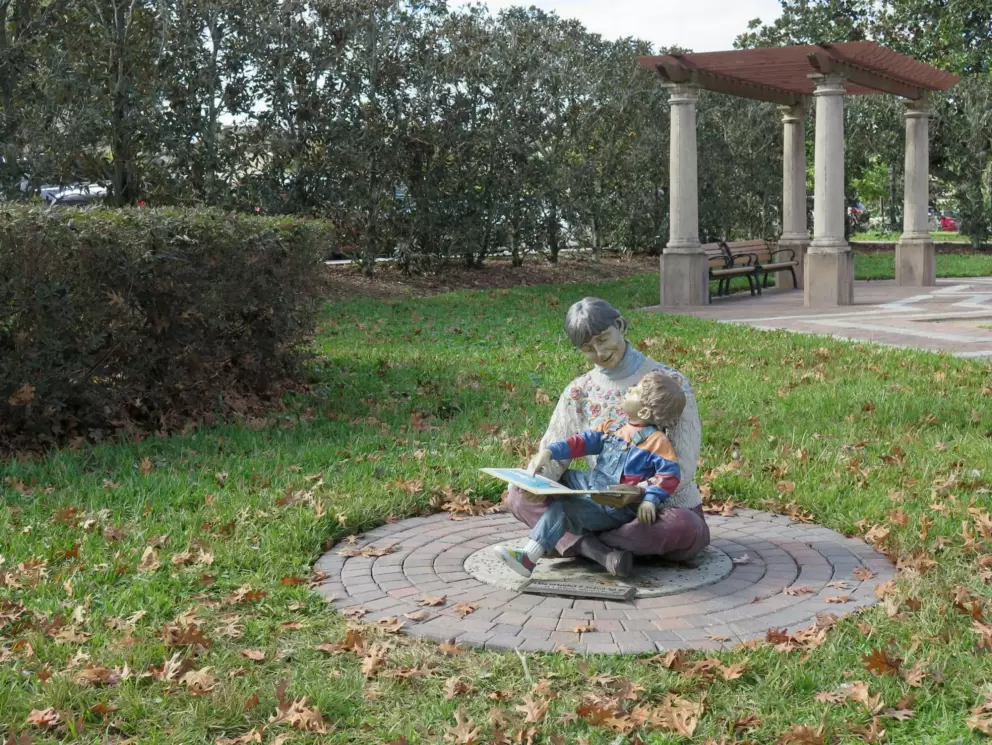 Sculpture of a mom reading to a child.