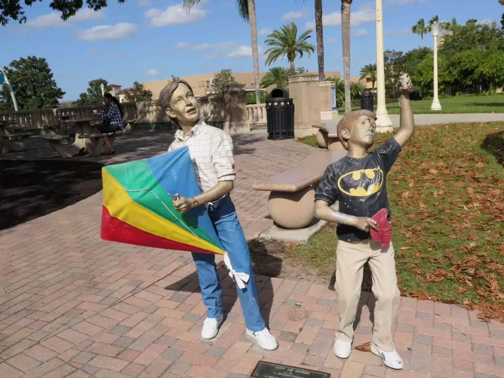 Sculpture of dad and son flying a kite.