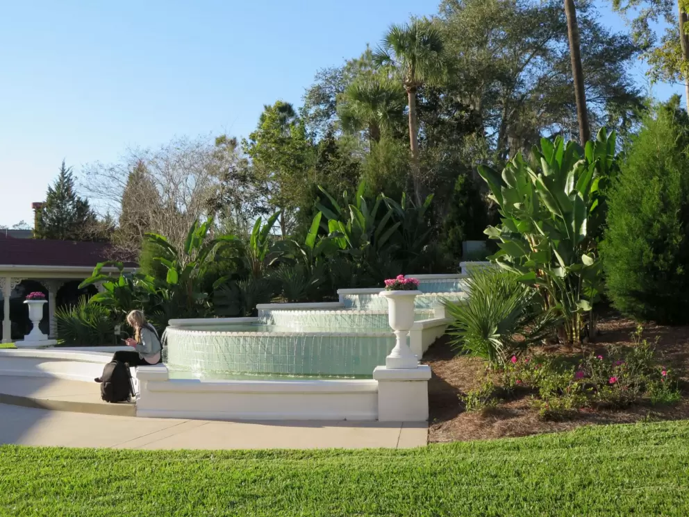 A guest waits by the fountain at the Grand Floridian.