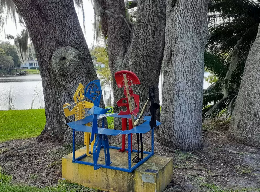 Sculpture by many tree trunks.