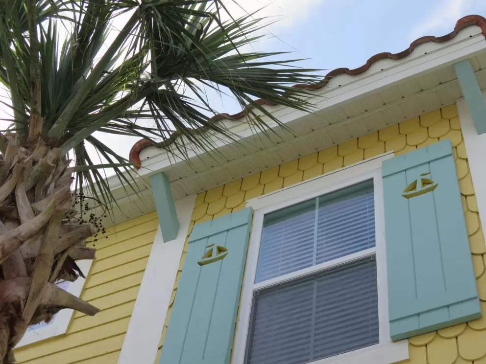 Sailboat cutout on blue-green shutters.