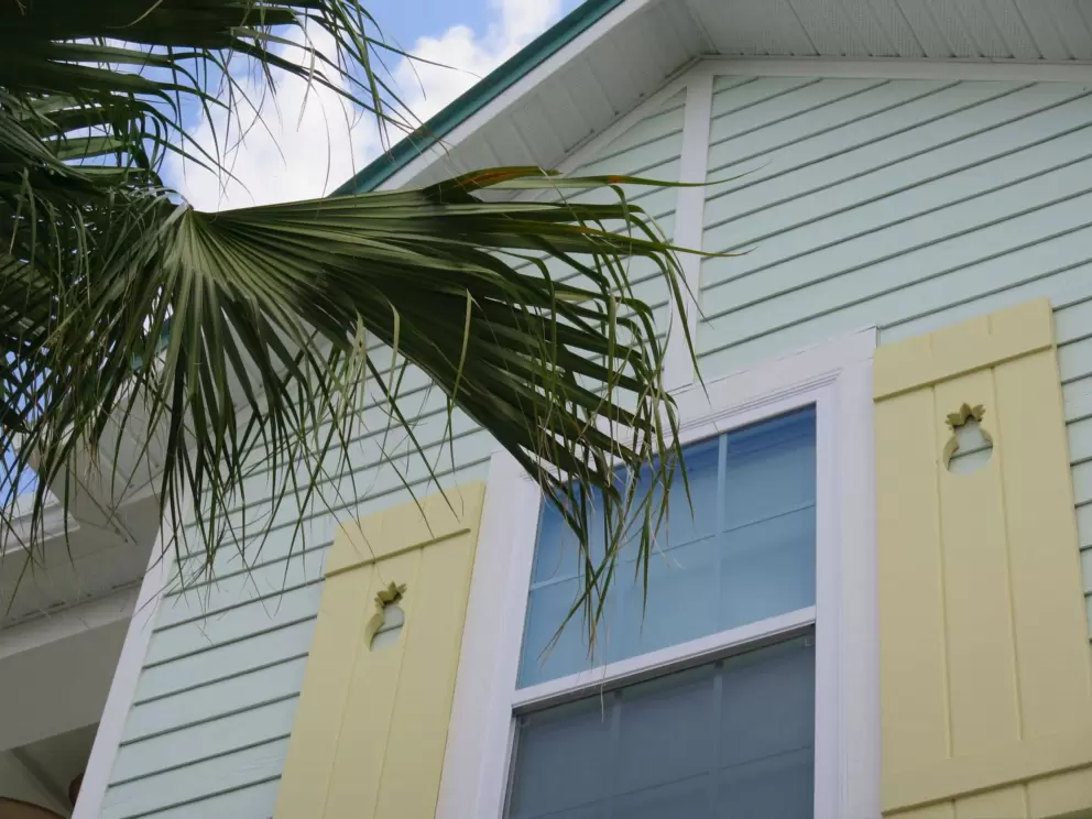 Pineapple cutouts on yellow shutters.