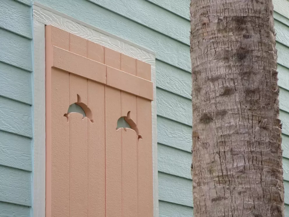 Dolphin cutouts on orange cream shutters.