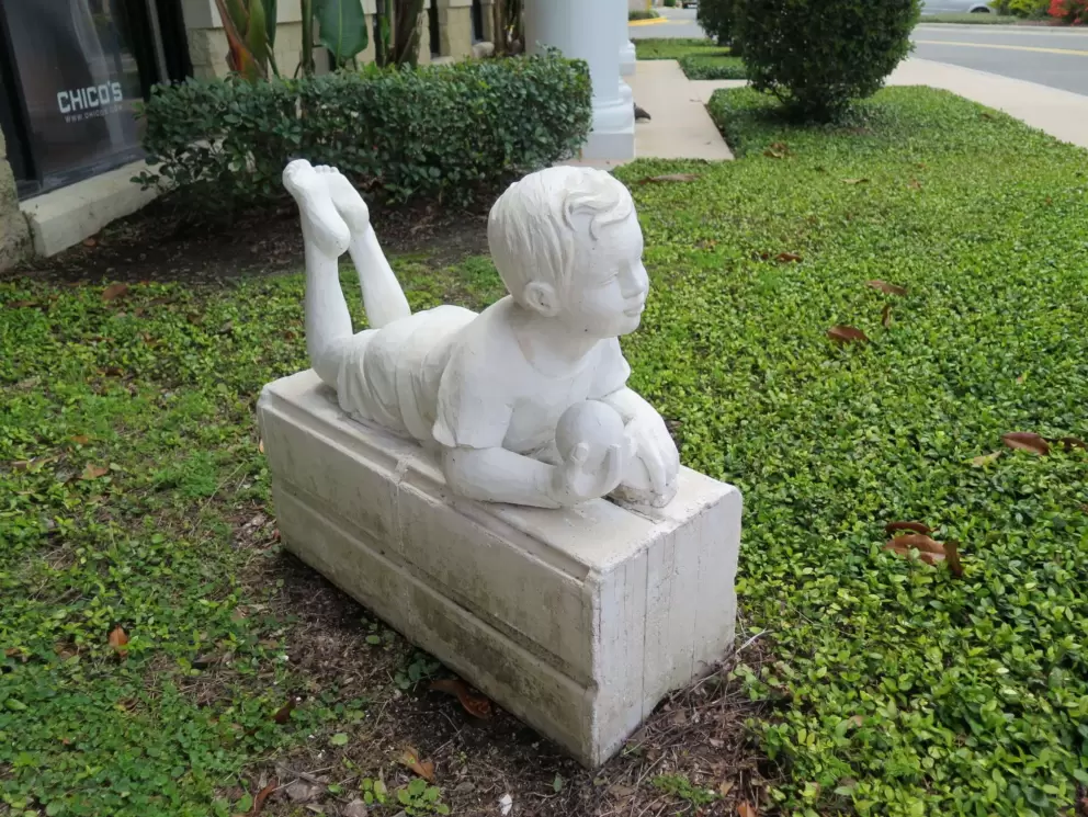 Sculpture of a little boy with a ball.