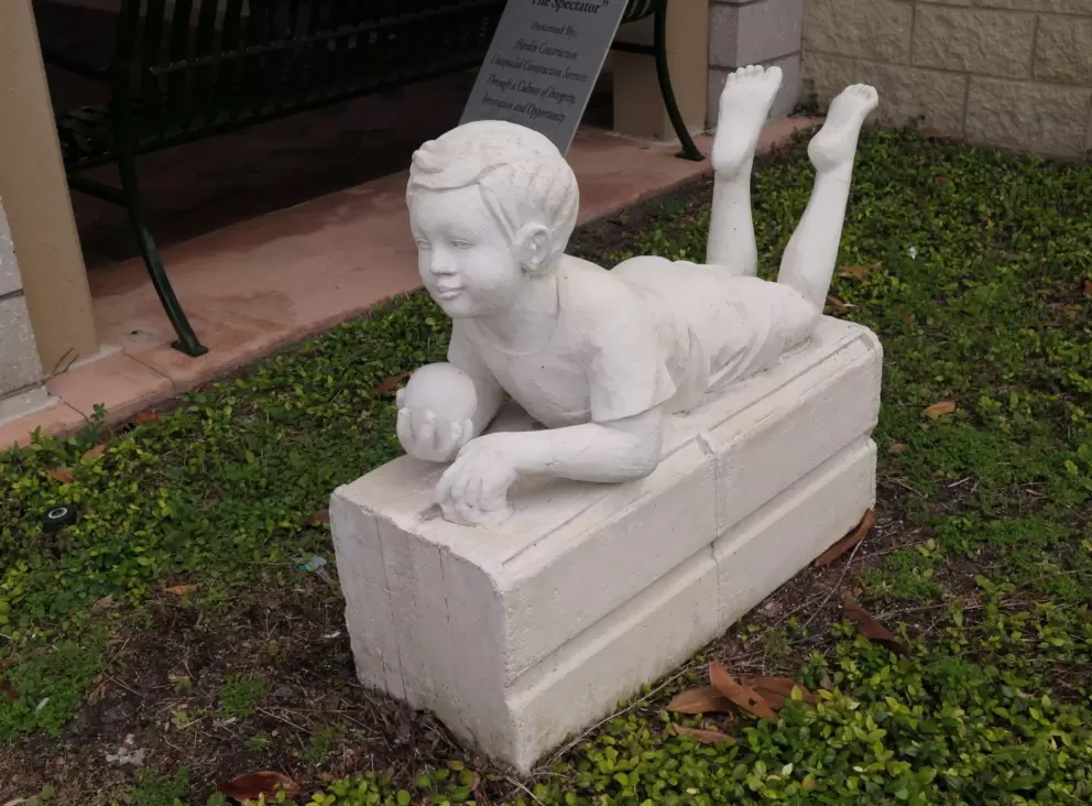 Sculpture of little boy, from other side.