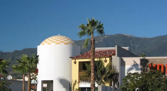 Yellow and white checkered roof, with mountains behind. 