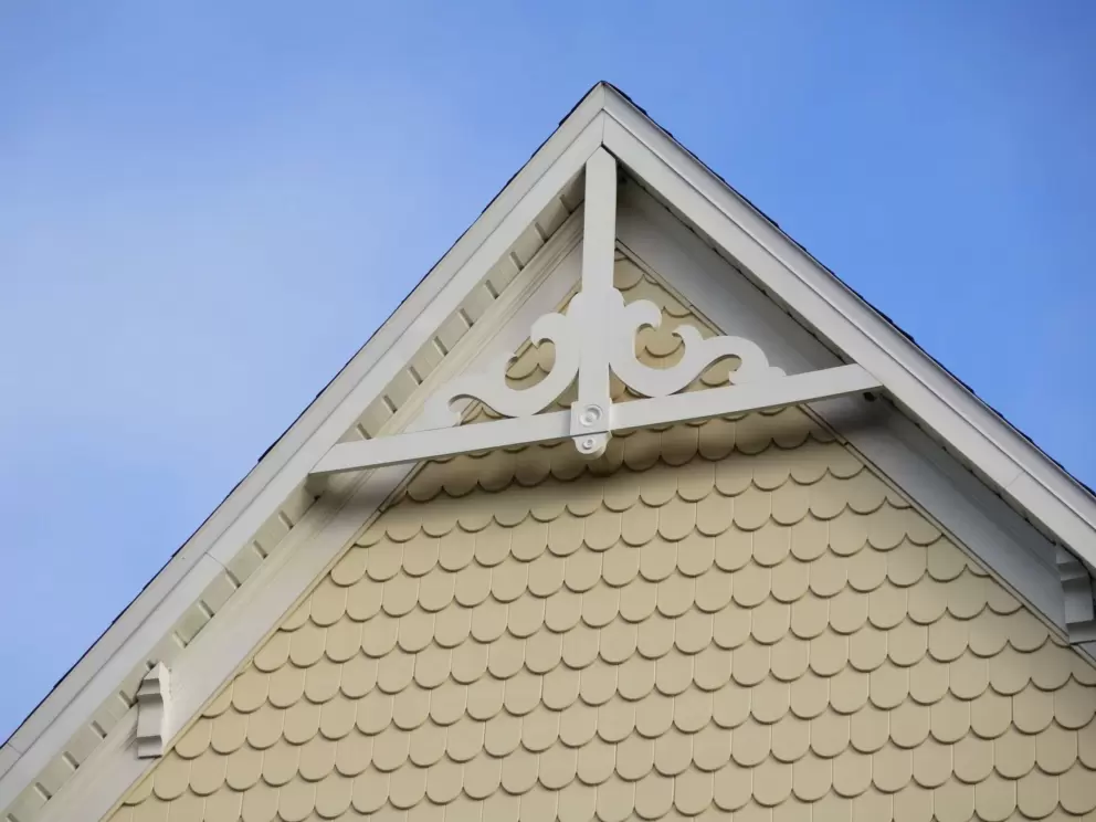 Shingles on the gable of a yellow Victorian house.