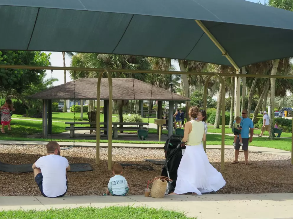 Parents gather by the baby swings at Humiston Beach Park.