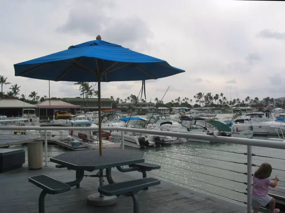 A picnic table by the water, on an overcast day at Koko Marina.